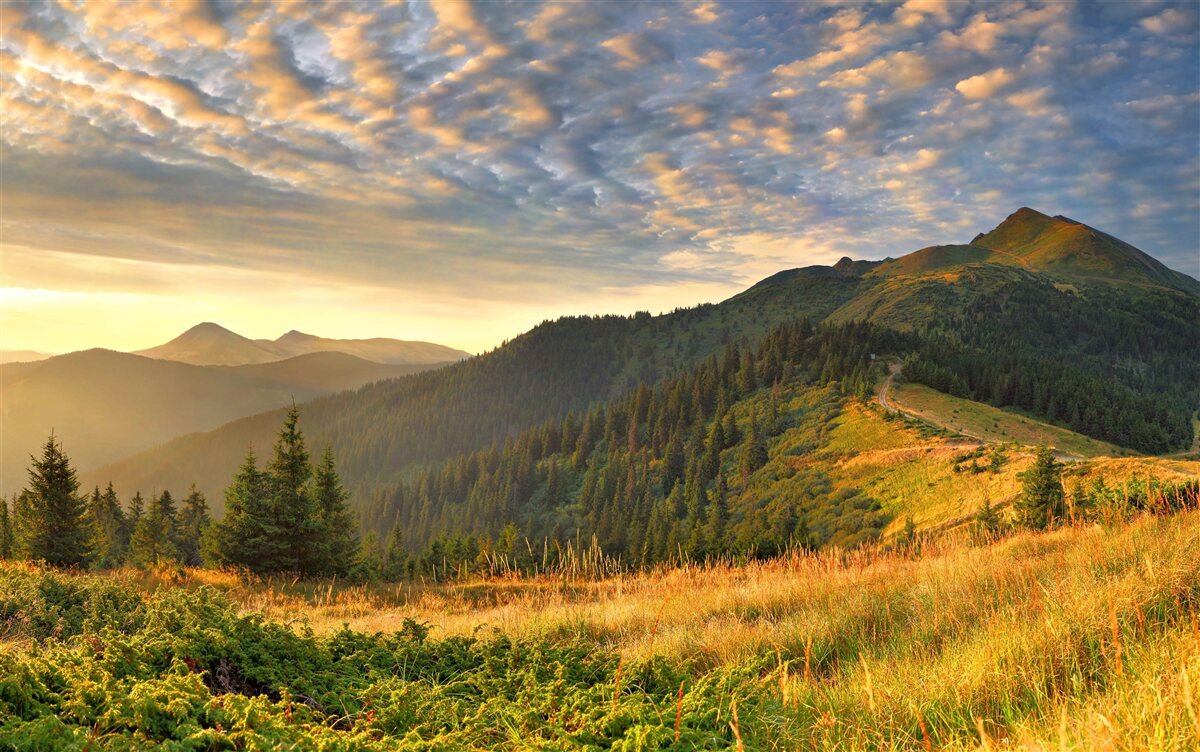 Fototapeta chmury nad górami pomalowane są w ciepłe kolory zachodu słońca