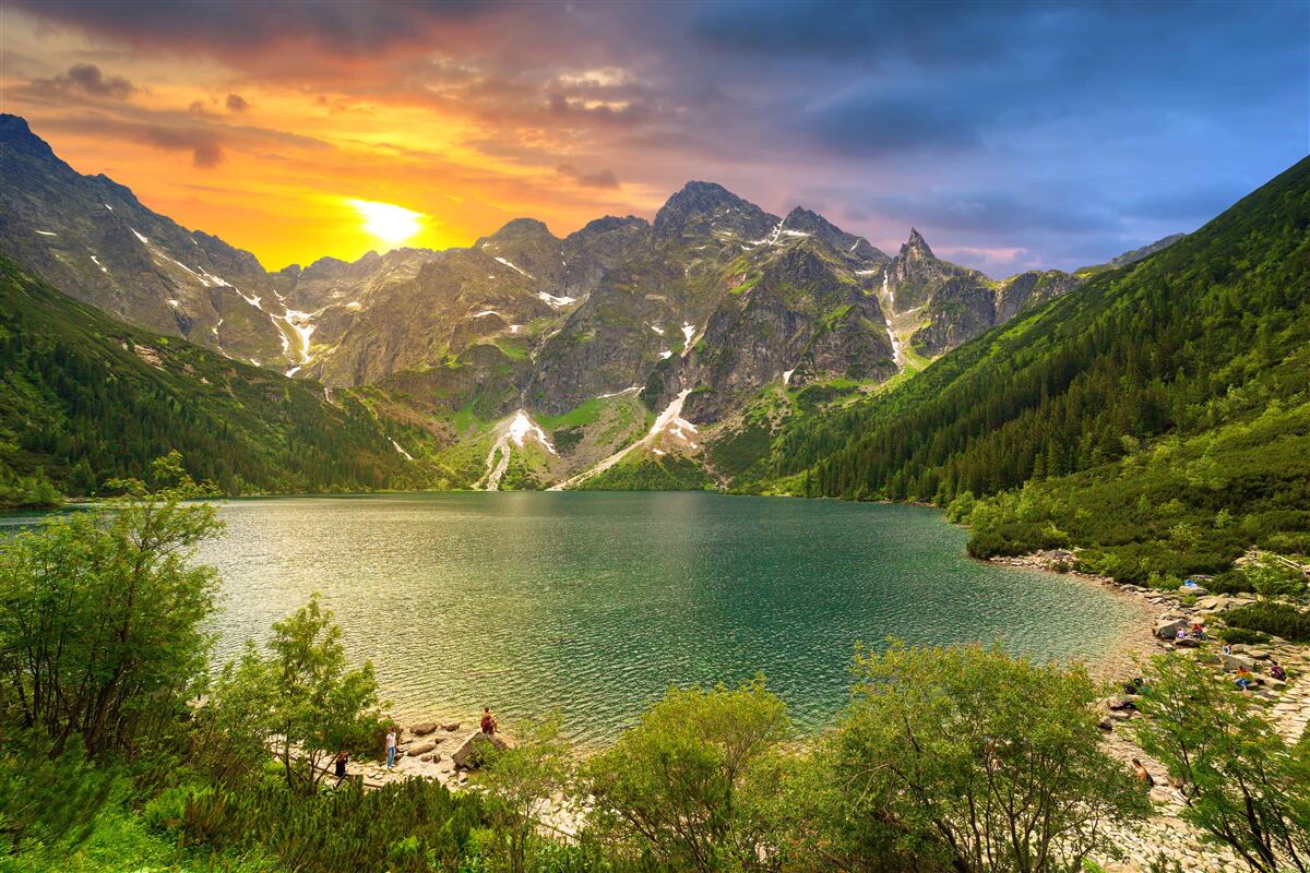 Fototapeta spektakularny zachód słońca za pasmami górskimi w pobliżu jeziora