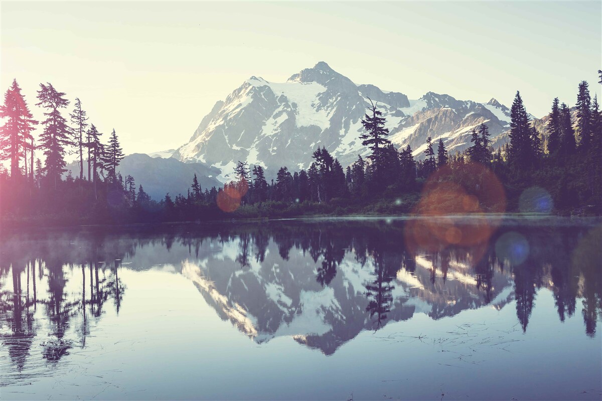 Fototapeta zapierający dech w piersiach widok na góry i lasy odbity w krystalicznie czystej wodzie
