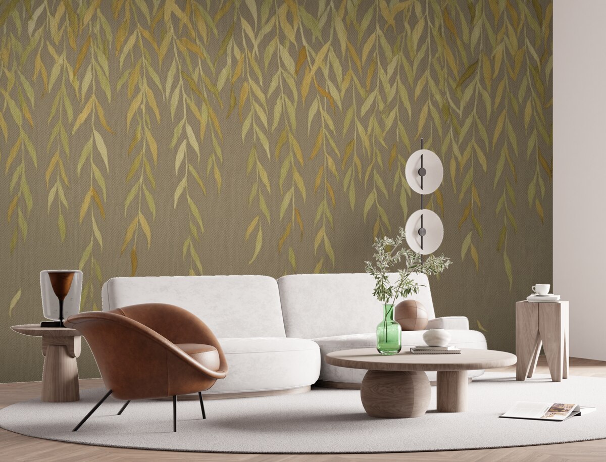 Fototapeta Gałęzie wierzby z liśćmi w odcieniach żółci i zieleni opadające na brązowym płóciennym tle.