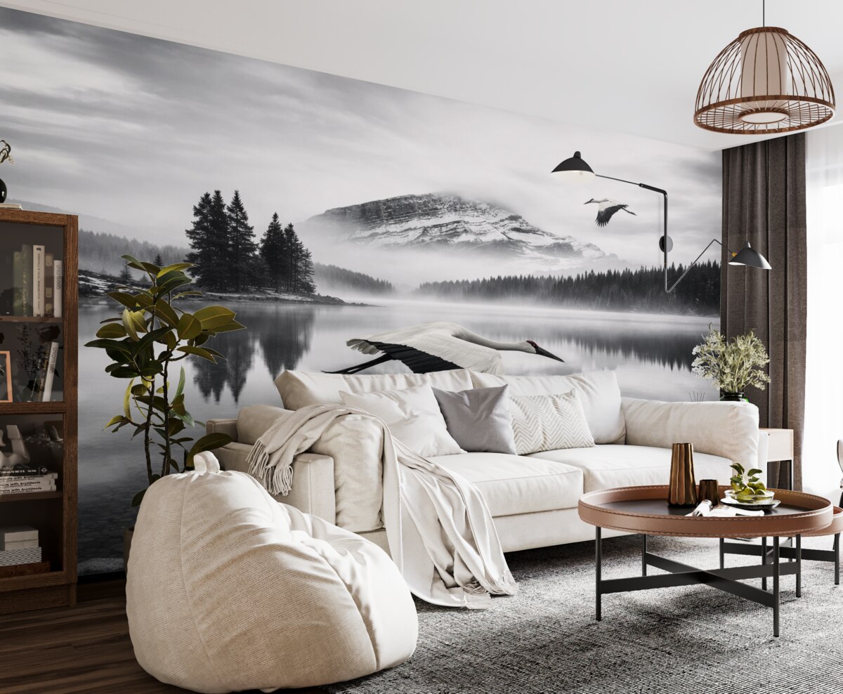 Fototapeta Bocian przelatuje nad rzeką i górami, czarno-biała sceneria z ptakami.