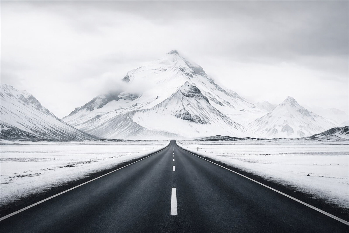 Fototapeta Czarno-biały pejzaż z trasą wiodącą w góry z delikatną mgłą.